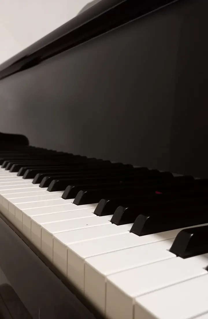 Clavier d'un piano droit noir vu en perspective rasante, touches blanches et noires alignées